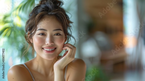 Radiant young Asian woman with a captivating smile in a tranquil indoor setting, exuding elegance and happiness