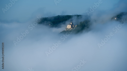 Chateau de Castelnaud in the mist on a blue morning photo