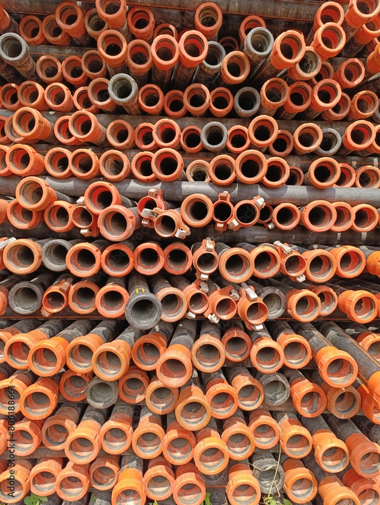 a pile of orange pipes with the words water supply on the bottom. a pile of orange pipes with the words water supply on the bottom.