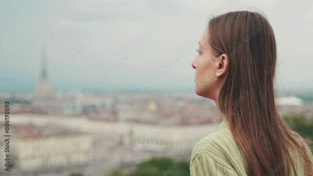 Close up, young woman looks at the city from the observation deck Close up, young woman looks at the city from the observation deck