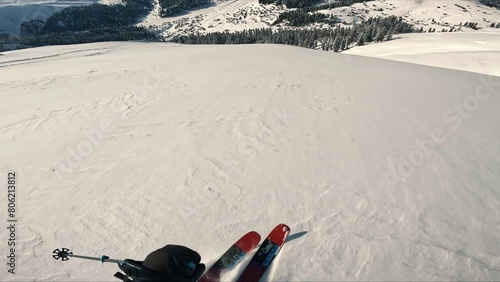  Freeride skiing down the untouched terrain of a remote mountain in wilderness. Riding in fresh powder snow