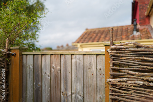 Shallow focus of a natural weave wattle fence seen at the back of holiday cottages on the east coast of England. The terraced back gardens are part of holiday lets on the east coast of England.