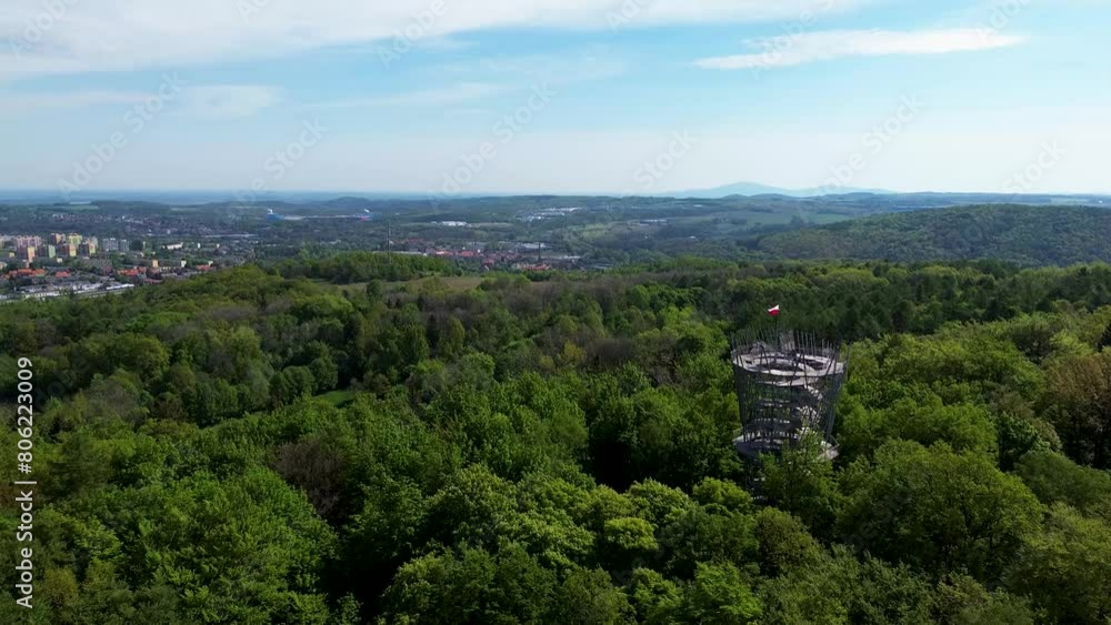 Lookout Tower on top of a hill in Poland, surrounded by mountain city in valley spring time flyover Lookout Tower on top of a hill in Poland, surrounded by mountain city in valley spring time flyover