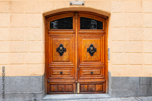 A wooden door with a handle in the wall of the house in close-up - Madrid, Spain