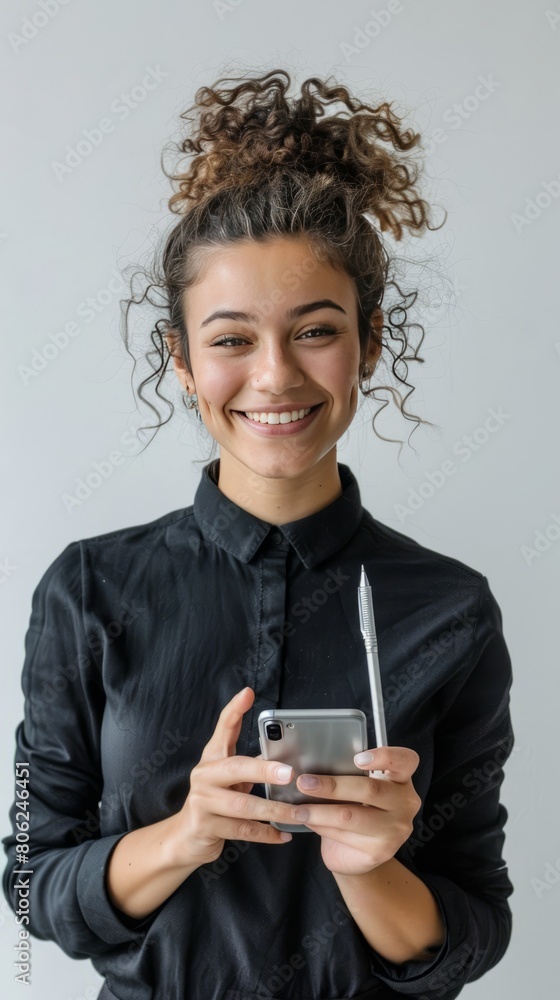 Smiling female entrepreneur holding smart phone and felt tip pen Smiling female entrepreneur holding smart phone and felt tip pen