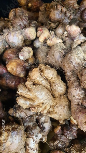 Close up pile of tasty fresh aromatic ginger sold at the market as a background.	
