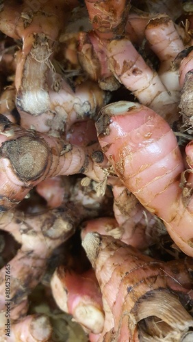 Close up pile of tasty fresh galangal sold at the market as a background.	
