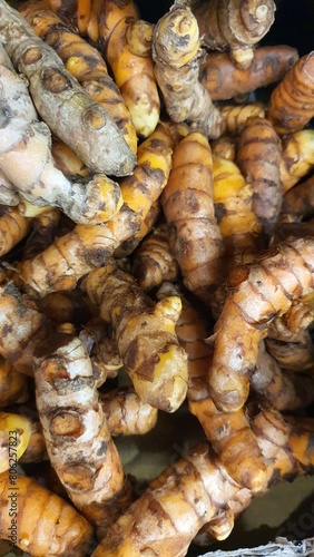 Close up pile of tasty fresh turmeric sold at the market as a background.	
