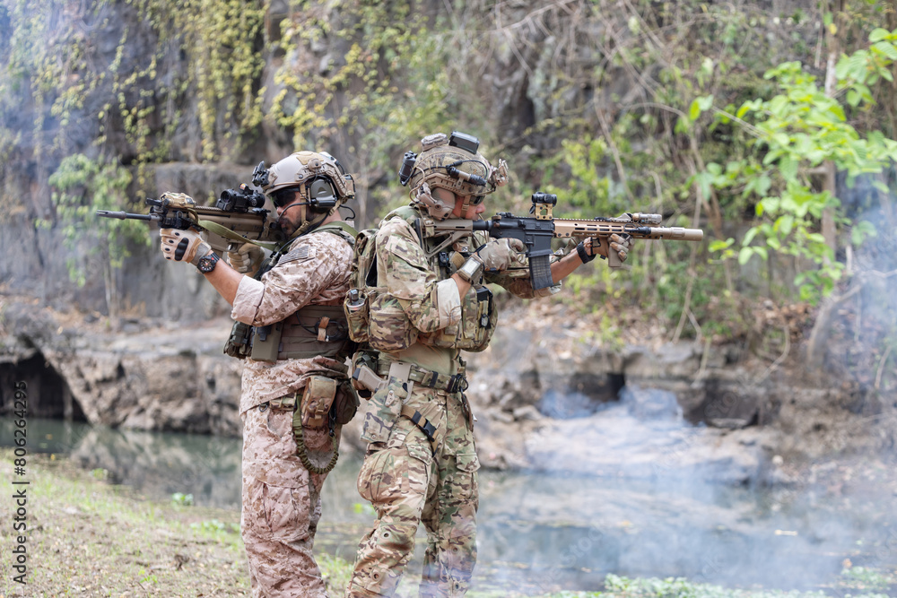 Fototapeta premium Soldiers in camouflage military uniforms in shooting position ready for battle