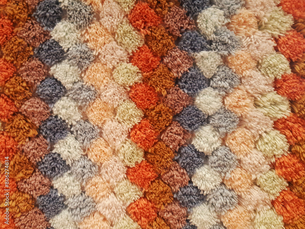Fototapeta premium Colorful knit plaid, home-made, crocheted blanket background of shaggy thread. Wool fabric carpet texture background.