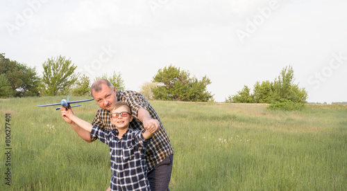 Obraz na płótnie Father and son having fun in the field playing with an airplane w salonie