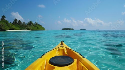 Bright yellow kayak glides across the crystal-clear waters of the maldives, with lush islands in the background