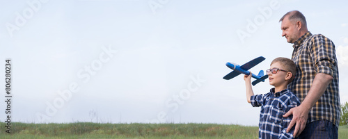 Obraz na płótnie Banner father and son in a field with an airplane. Father's day concept. w salonie