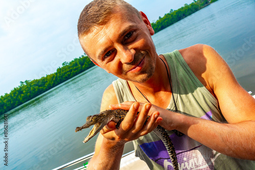 Man tourist with baby crocodile alligator Sri Lanka. photo