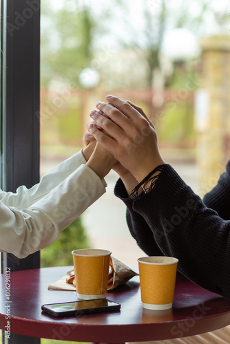 Couple enjoying a coffee holding hands.