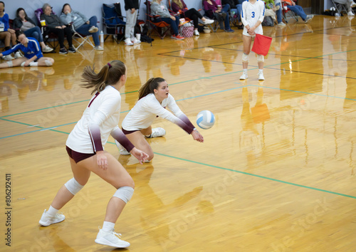 College volleyball player on her knee digging a hit