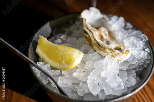 Fresh oyster in dish with lemon and wine
