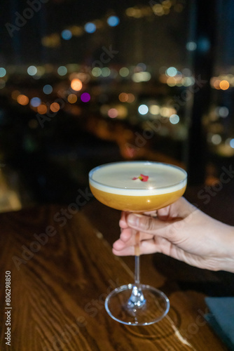 A woman's hand holds a glass of a delicious cocktail. Concept of cocktails, alcoholic drinks, taste, party, mix.