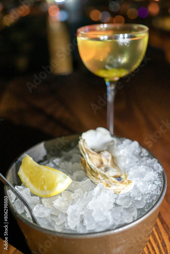 Fresh oyster in dish with lemon and wine.
