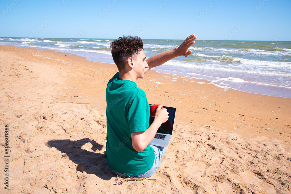 Summer and work on the beach. A young attractive student is resting near the seashore.