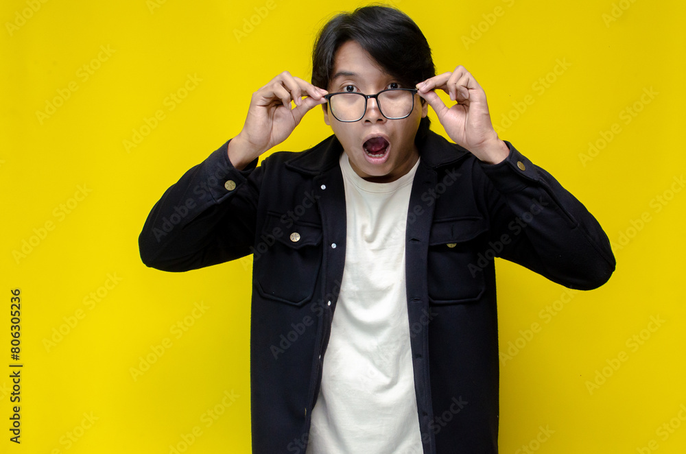 Ecstatic asian man touching face and lowering his glasses as a shocked and surprissed exppression. Ecstatic asian man touching face and lowering his glasses as a shocked and surprissed exppression.
