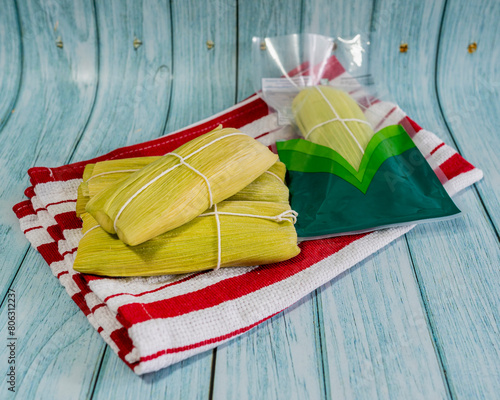 Peruvian sweet humitas, served on a cloth tablecloth, sweet humita inside a transparent bag. Close-up detail. Green tamale. photo