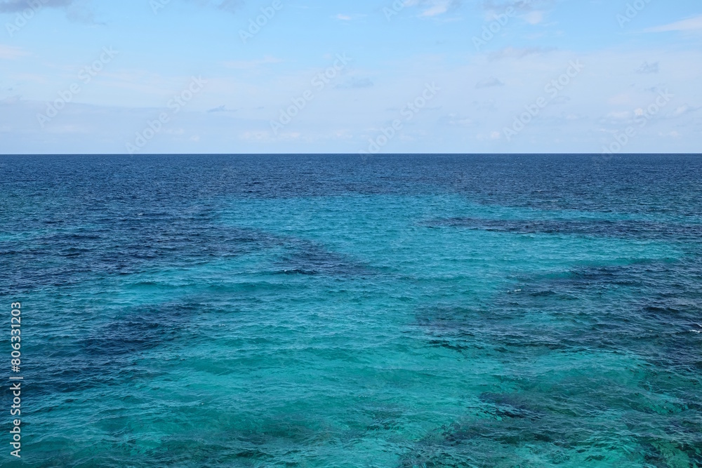 Türkisblaues Wasser am Mittelmeer mit Sand und Korallen vor Blauem Himmel an einem Sonnentag Querformat Türkisblaues Wasser am Mittelmeer mit Sand und Korallen vor Blauem Himmel an einem Sonnentag Querformat