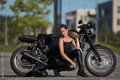 Portrait of young woman on a black motorcycle