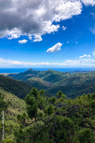 Clouds on blue sky over mountains and sea in Sierra de las Nieves National Park, Andalusia, southern Spain