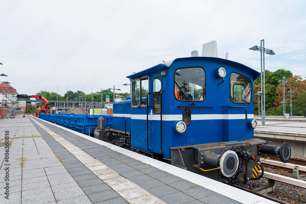 Eine Kleinlok älteren Baujahrs mit einem Arbeitszug am Bahnsteig Eine Kleinlok älteren Baujahrs mit einem Arbeitszug am Bahnsteig