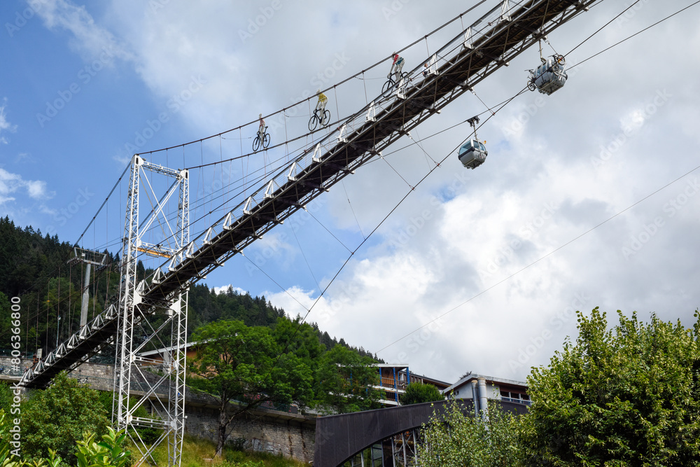 Cable cars and a foot bridge allow cyclists and people to reach the mountain top at a ski resort Cable cars and a foot bridge allow cyclists and people to reach the mountain top at a ski resort
