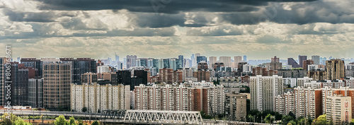 Panorama of the city, top view. Multi-storey buildings and railways are illuminated by the rays of the sun through thunderclouds. Moscow, Khovrino district. photo