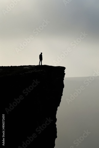 Photo of lone figure standing at the edge of a cliff, introspection, generated with AI