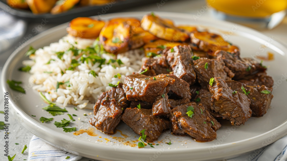 Colombian cuisine: succulent beef pieces in a rich sauce with white rice, fried plantains, and fresh parsley served on a plate Colombian cuisine: succulent beef pieces in a rich sauce with white rice, fried plantains, and fresh parsley served on a plate