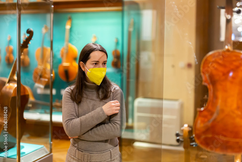 Canvas Print Portrait of interested adult brunette wearing protective face mask visiting exhi