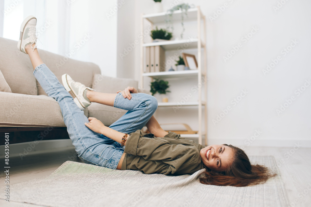 Cosy, Relaxing Apartment: A Happy Woman Lying on a Modern Sofa in a Peaceful Living Room. Cosy, Relaxing Apartment: A Happy Woman Lying on a Modern Sofa in a Peaceful Living Room.