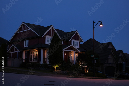 Framing a shot of a two-story luxury home with a beautiful landscape at night in Vancouver, Canada, North America. Night, photo