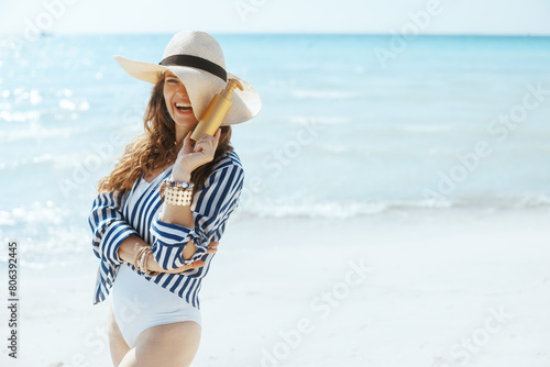 smiling elegant woman on seashore with spf