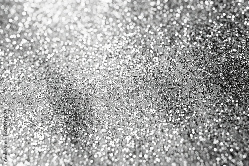 A close up of a silver glittery surface. The surface is made up of many small silver dots