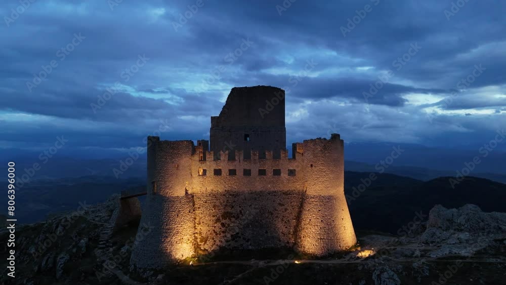 Aerial view of illuminated Rocca Calascio castle in Abruzzo, Italy on top of mountain at evening Aerial view of illuminated Rocca Calascio castle in Abruzzo, Italy on top of mountain at evening