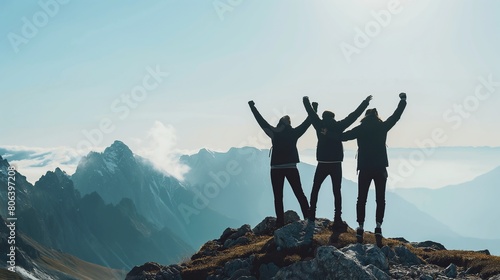 Together overcoming obstacles with three people holding hands up in the air on mountain top. We Made It. Celebrating success and achievements.