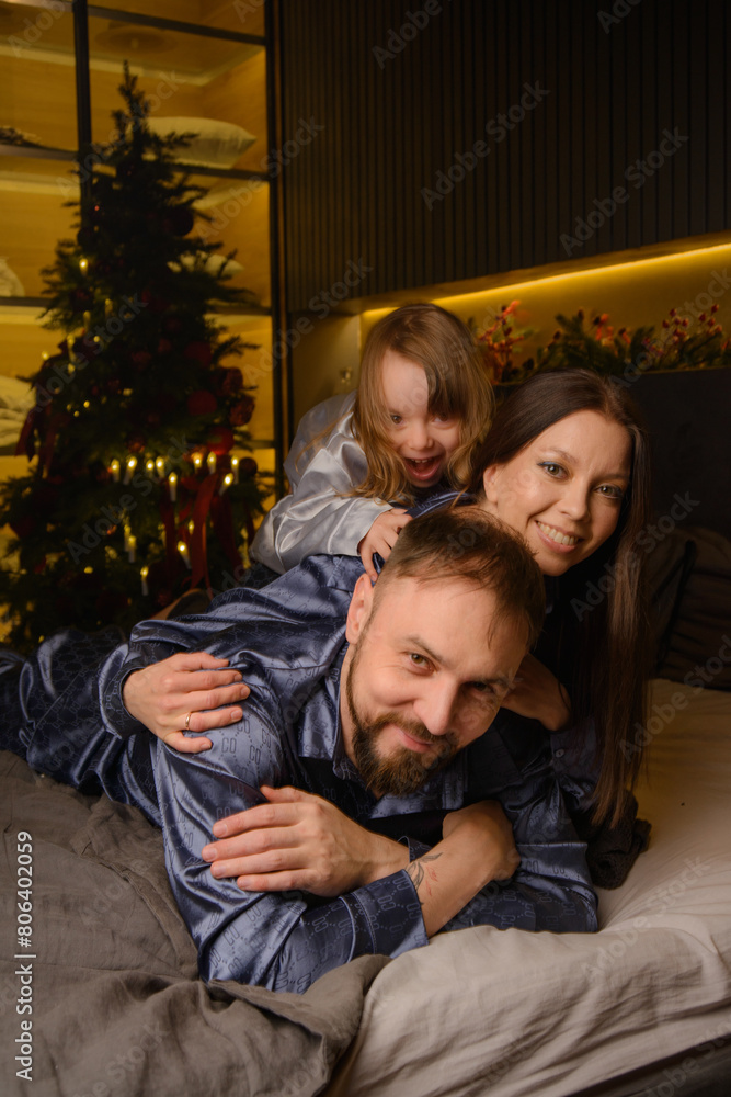 A happy family poses in pajamas in New Year's locations. A happy family poses in pajamas in New Year's locations.