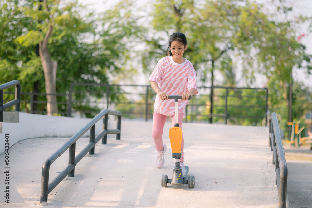 A young girl riding a scooter down a ramp A young girl riding a scooter down a ramp