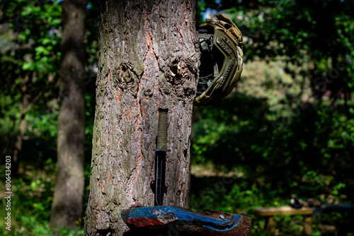 Military assault helmet and tactical knife in the forest on a tree.
Military equipment, tactical equipment. Soldier's War in Ukraine photo