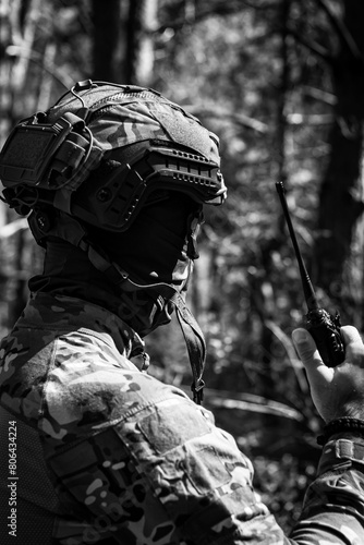 A military man in a tactical helmet and balaclava communicates on a walkie-talkie.
Military affairs, war in Ukraine. Combat actions, situational awareness
Black and white photo