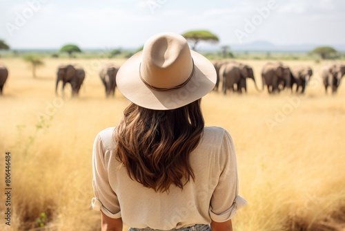 woman observing elephants in the african savanna
