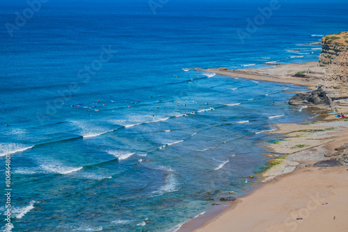 Aerial view of Ribeira d'Ilhas beach with silhouettes of surfers and boards in the sea, Ericeira - Mafra PORTUGAL © Liliana