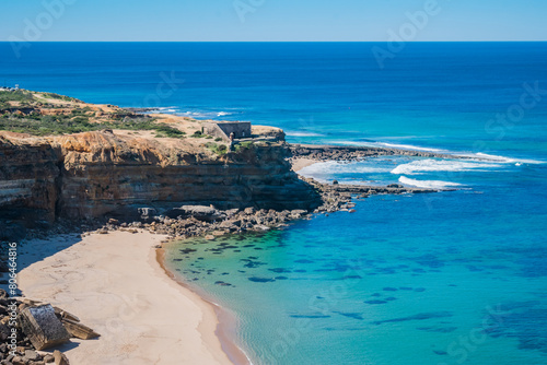 Alibabá beach with transparent sea and Milreu fort in cliff, Ericeira - Mafra PORTUGAL
