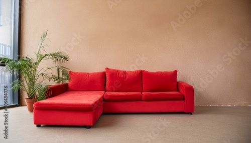 Red modular corner sofa against blank brown stucco wall with copy space. Loft interior design of modern living room  home.