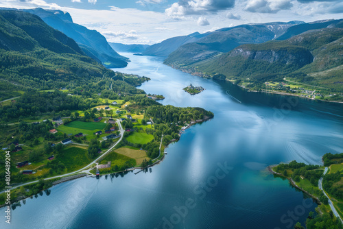Aerial view of the beautiful Norwegian fjord surrounded by green mountains and fields  blue water flowing into it.